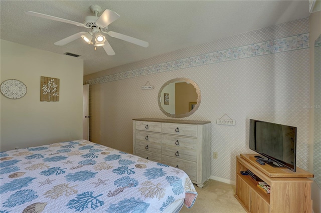 carpeted bedroom featuring a textured ceiling and ceiling fan