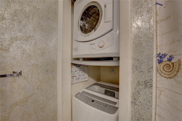 clothes washing area featuring stacked washer and dryer