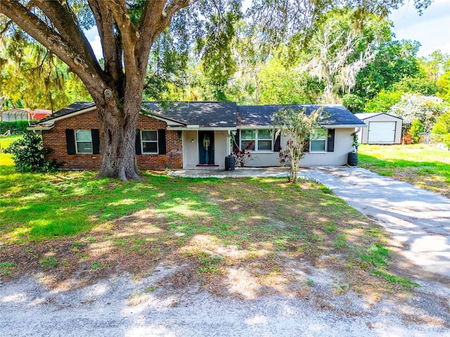 ranch-style home with a garage, a front lawn, and an outdoor structure