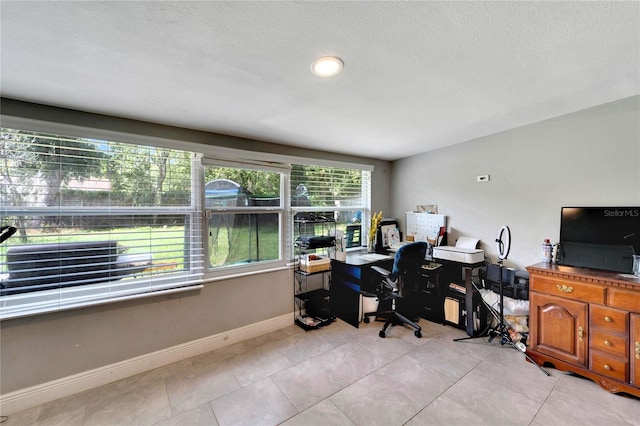 office space with a textured ceiling and light tile patterned floors