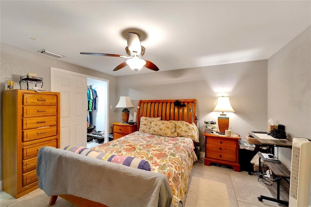 bedroom featuring a closet, a spacious closet, light tile patterned flooring, and ceiling fan