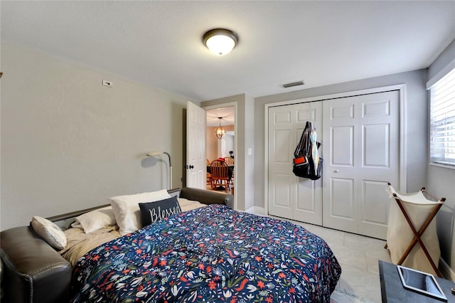 bedroom featuring an inviting chandelier and a closet