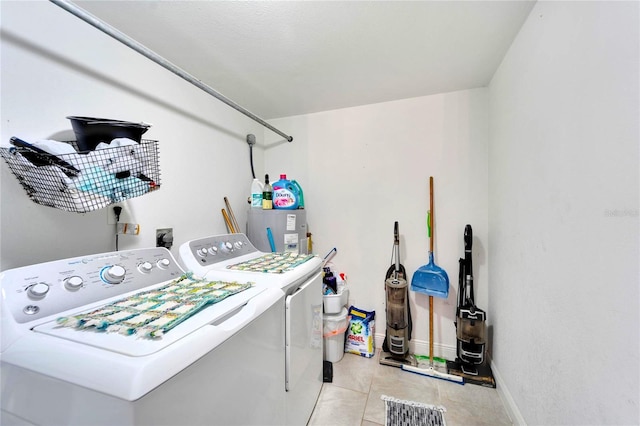 washroom with water heater, washer and clothes dryer, and light tile patterned flooring