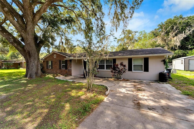 ranch-style home with a patio, an outbuilding, and a front lawn