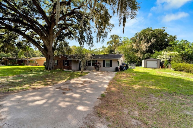 ranch-style home with a front yard, an outbuilding, and a garage