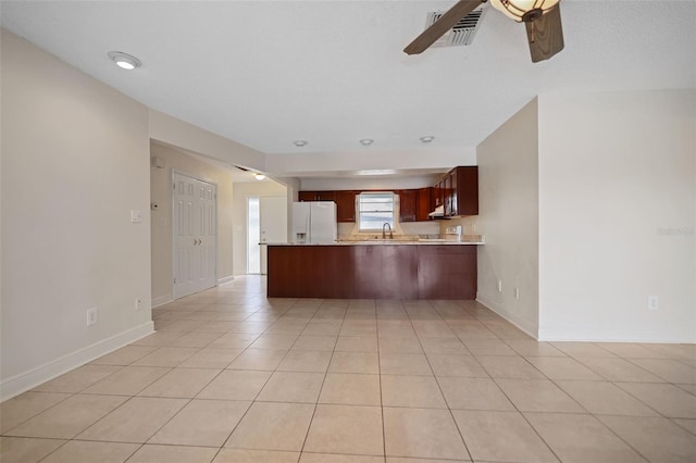 kitchen featuring kitchen peninsula, light tile patterned floors, white refrigerator with ice dispenser, and ceiling fan