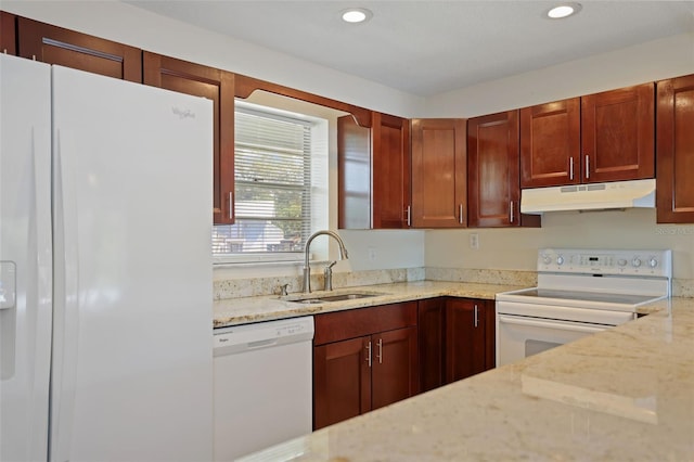 kitchen with white appliances, light stone counters, and sink