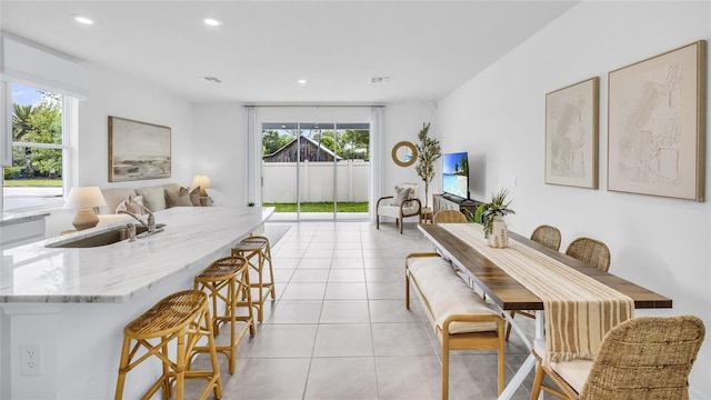 dining space featuring light tile patterned flooring and sink