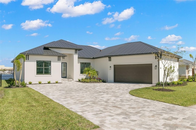 1810 4th St E, Palmetto, FL 34221 - view of front of home featuring stucco siding, decorative driveway, a garage, a front yard, and metal roof