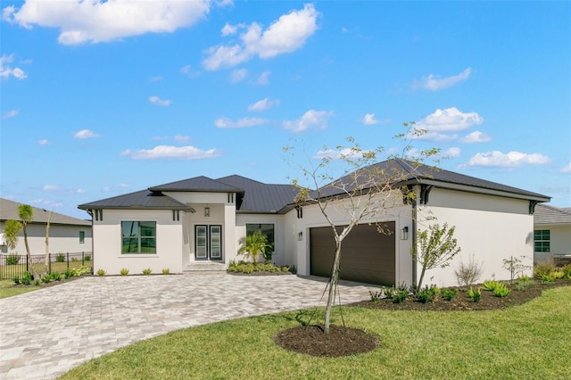 1810 4th St E, Palmetto, FL 34221 - view of front of home with decorative driveway, stucco siding, a garage, and metal roof