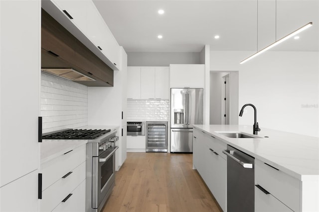 1810 4th St E, Palmetto, FL 34221 - kitchen with beverage cooler, modern cabinets, high quality appliances, a sink, and extractor fan