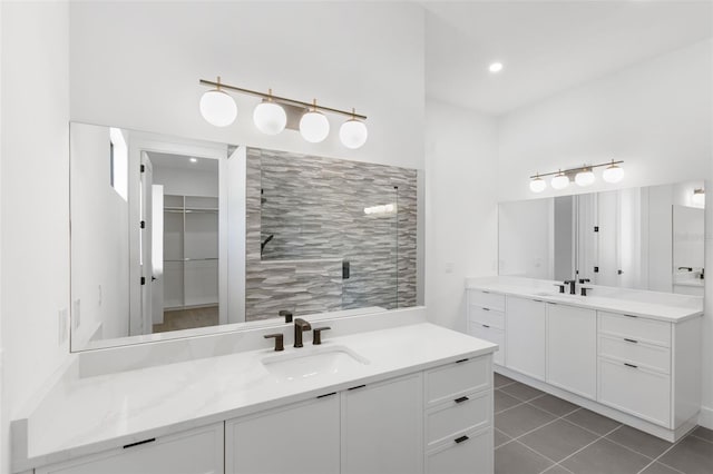 bathroom featuring a tile shower, vanity, and tile patterned flooring