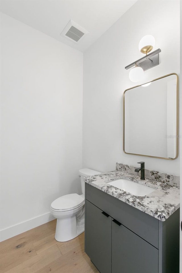 bathroom with vanity, hardwood / wood-style flooring, and toilet