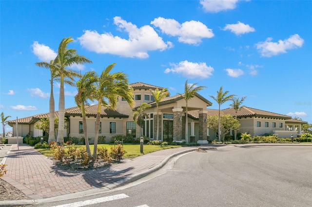 1810 4th St E, Palmetto, FL 34221 - mediterranean / spanish-style house with a tile roof, stone siding, and stucco siding