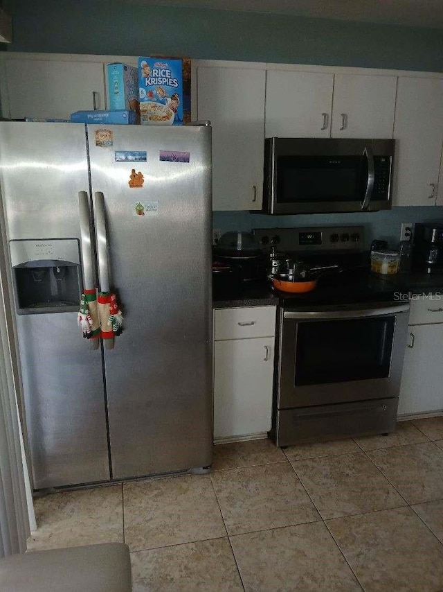 kitchen featuring white cabinets, light tile patterned flooring, and appliances with stainless steel finishes