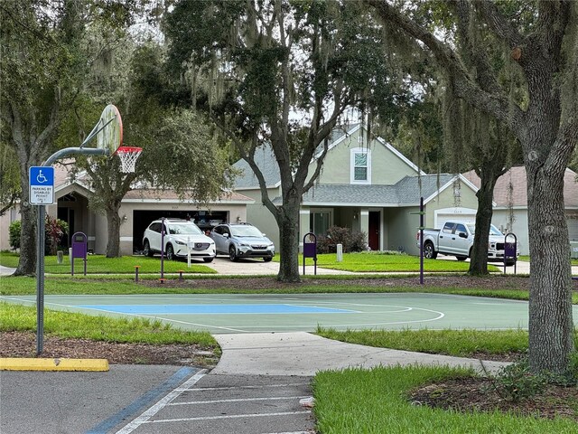 view of sport court featuring a lawn