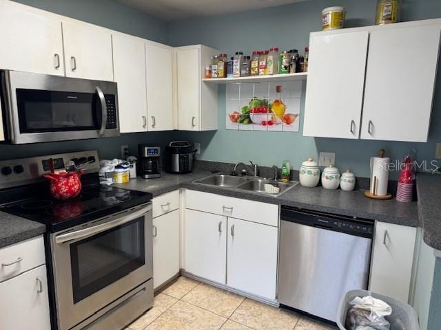 kitchen featuring sink, stainless steel appliances, white cabinets, and light tile patterned floors