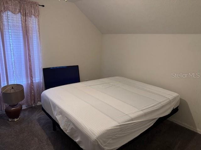 carpeted bedroom featuring lofted ceiling