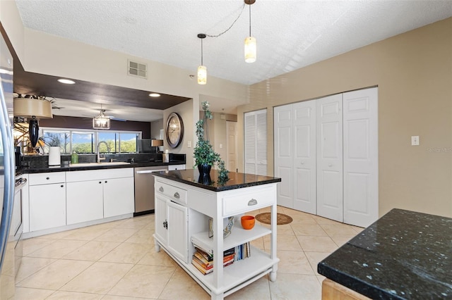 kitchen with dishwasher, white cabinets, a kitchen island, and a textured ceiling