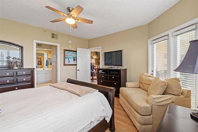 bedroom with a textured ceiling, multiple windows, and ceiling fan