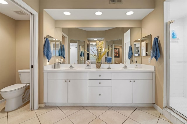 bathroom featuring walk in shower, vanity, tile patterned flooring, and toilet