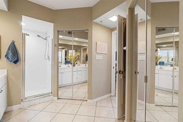 bathroom featuring vanity, an enclosed shower, and tile patterned floors