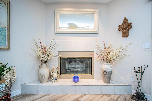 room details with a tiled fireplace and wood-type flooring