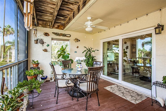 sunroom / solarium featuring beam ceiling and ceiling fan