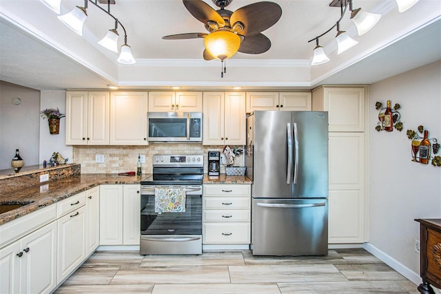 kitchen featuring decorative backsplash, ceiling fan, stainless steel appliances, dark stone counters, and ornamental molding