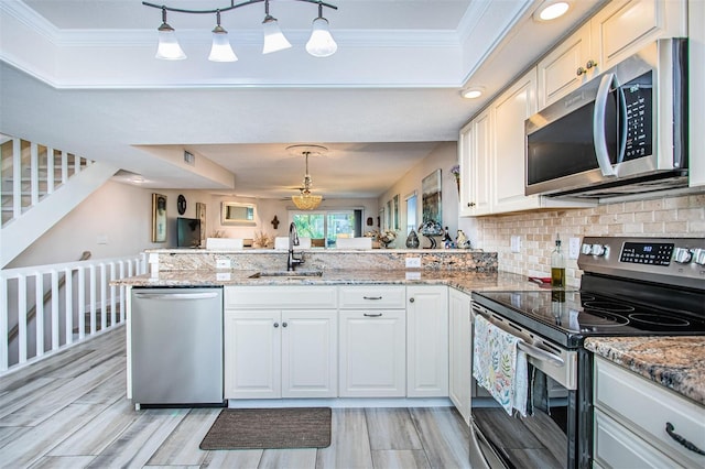 kitchen with sink, decorative light fixtures, stainless steel appliances, and kitchen peninsula