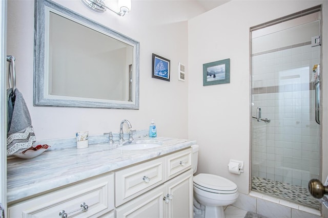 bathroom featuring vanity, toilet, and a shower with door