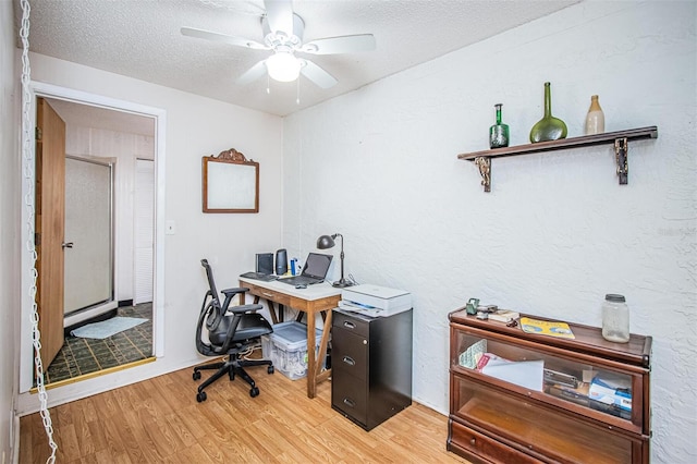 office featuring a textured ceiling, wood-type flooring, and ceiling fan