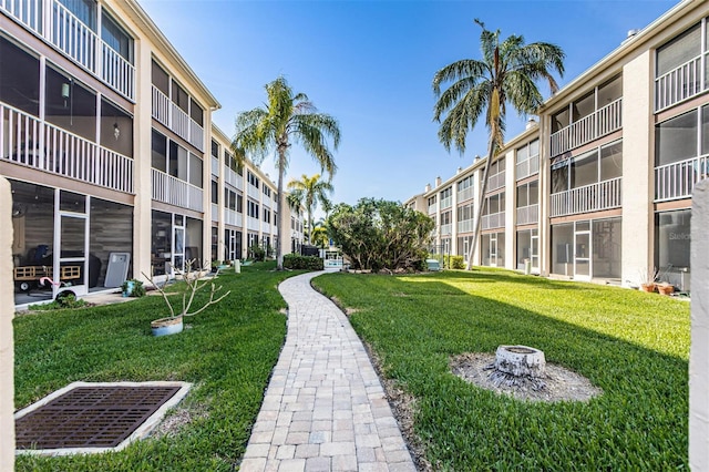 view of community with a lawn and a fire pit