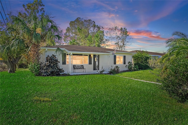 4300 16th Ave N, Saint Petersburg, FL 33713 - back of property at dusk with a yard, stucco siding, and a porch