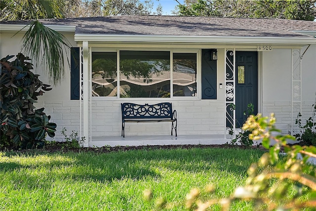 doorway to property featuring a lawn