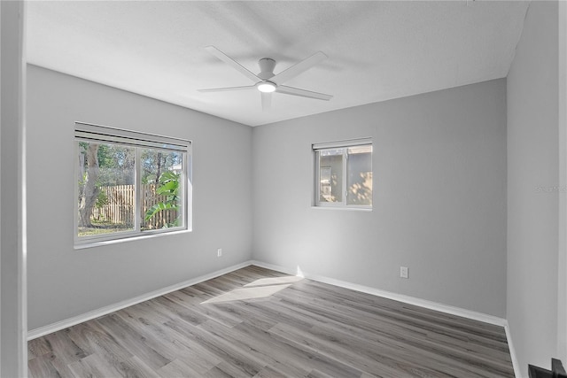 empty room with ceiling fan, hardwood / wood-style flooring, and a textured ceiling