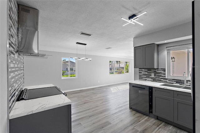 kitchen with a textured ceiling, light wood-type flooring, dishwasher, gray cabinetry, and sink