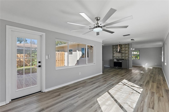 unfurnished living room featuring wood-type flooring and ceiling fan