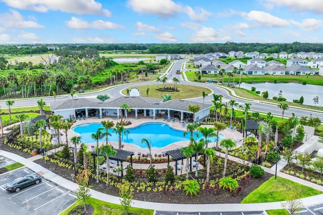 view of swimming pool with a water view and a patio area