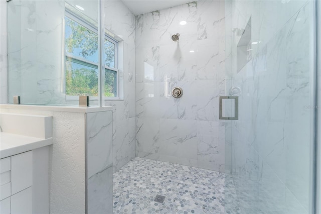 bathroom with vanity and tiled shower