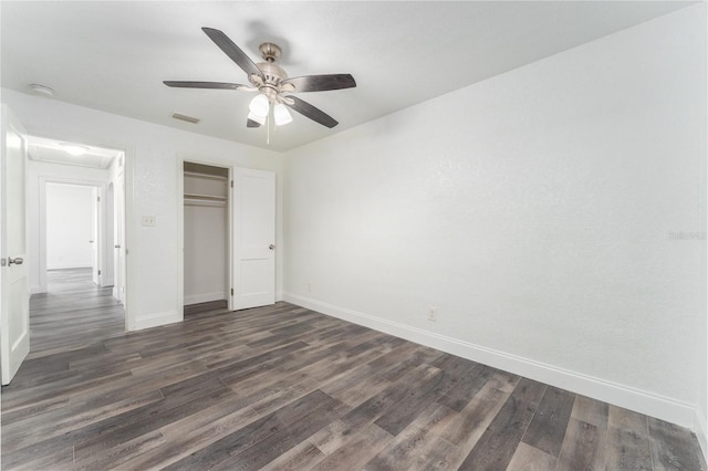 unfurnished bedroom featuring a closet, ceiling fan, and dark hardwood / wood-style flooring