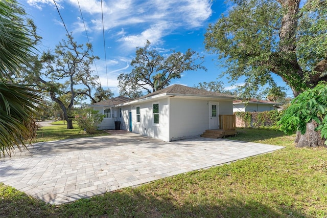 rear view of property featuring a patio area and a lawn