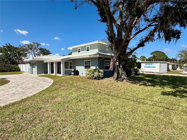 view of front facade with a front lawn and central AC