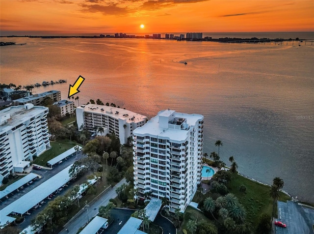 aerial view at dusk featuring a water view