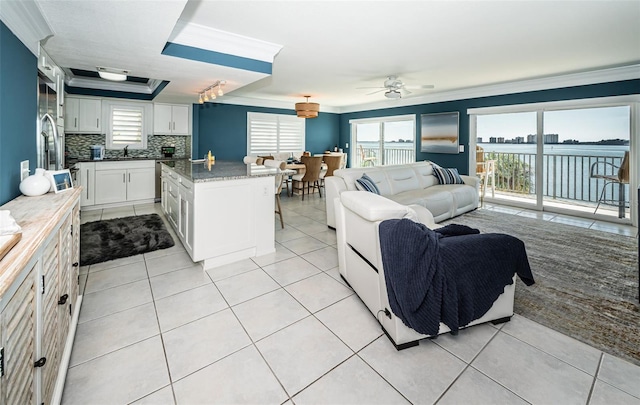 tiled living room featuring ornamental molding, sink, and ceiling fan