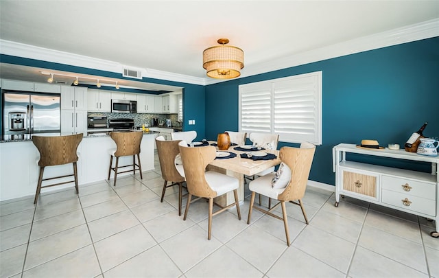 dining space with light tile patterned flooring and ornamental molding