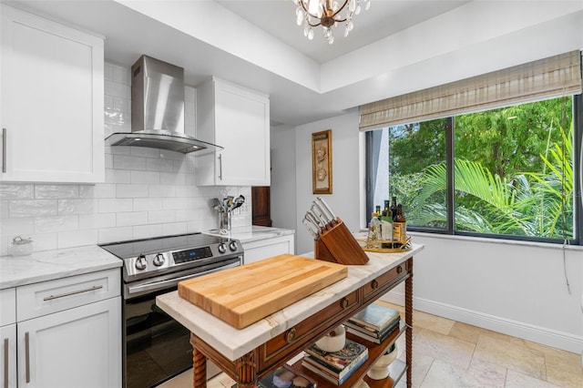 kitchen with wall chimney range hood, backsplash, electric range, white cabinets, and light stone counters