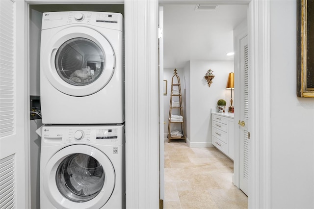 washroom featuring stacked washer / drying machine