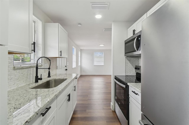 kitchen featuring appliances with stainless steel finishes, sink, dark hardwood / wood-style floors, and white cabinets