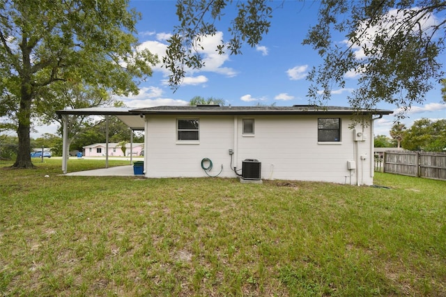 rear view of property featuring a yard and central AC